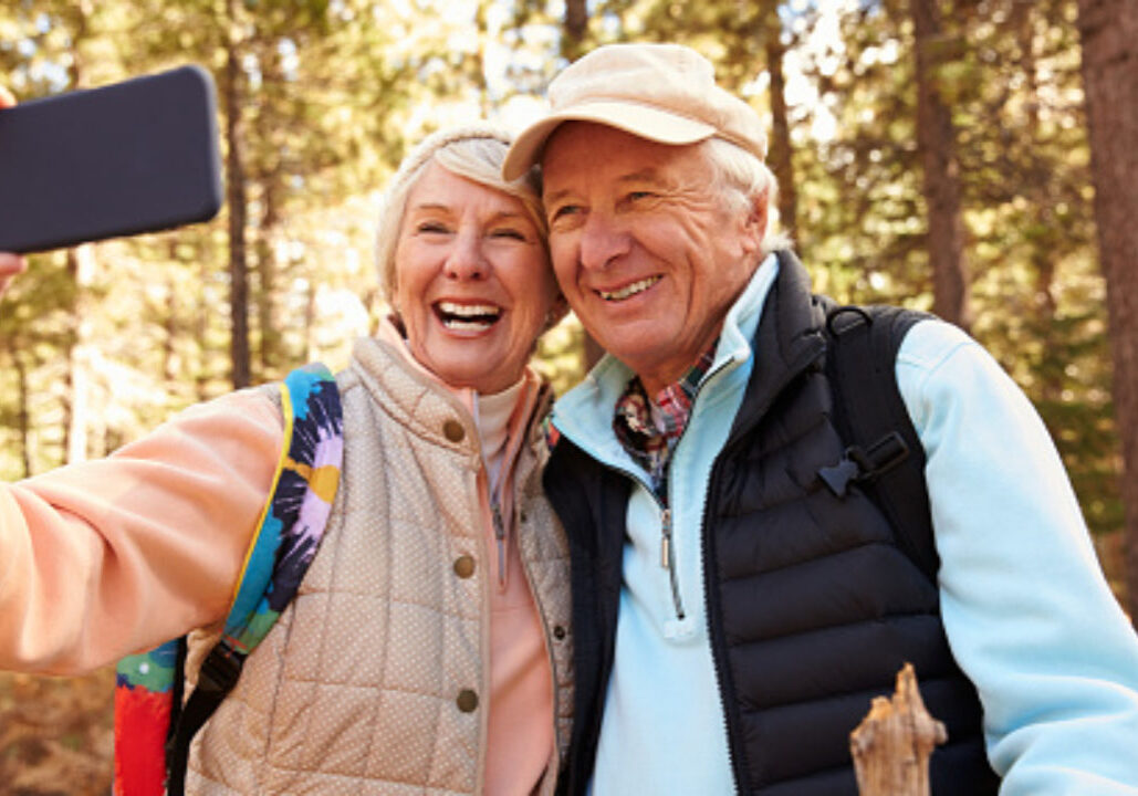 Senior couple on hike in a forest taking a selfie